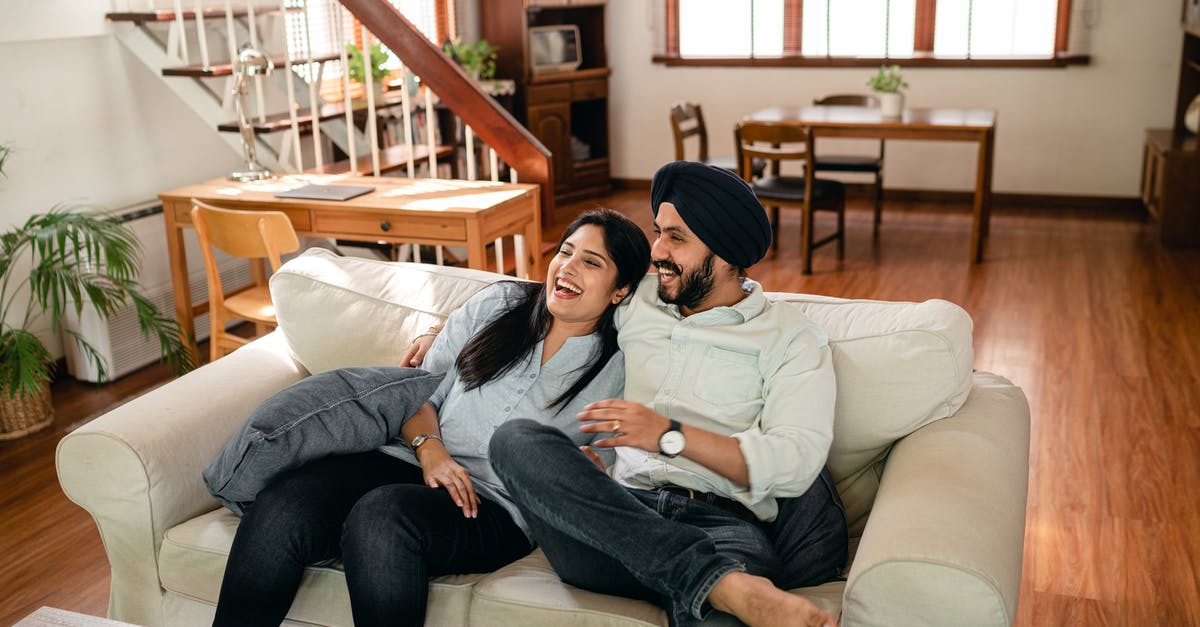 Will my boyfriend have any issues at UK border? [closed] - Laughing young Indian couple cuddling on sofa