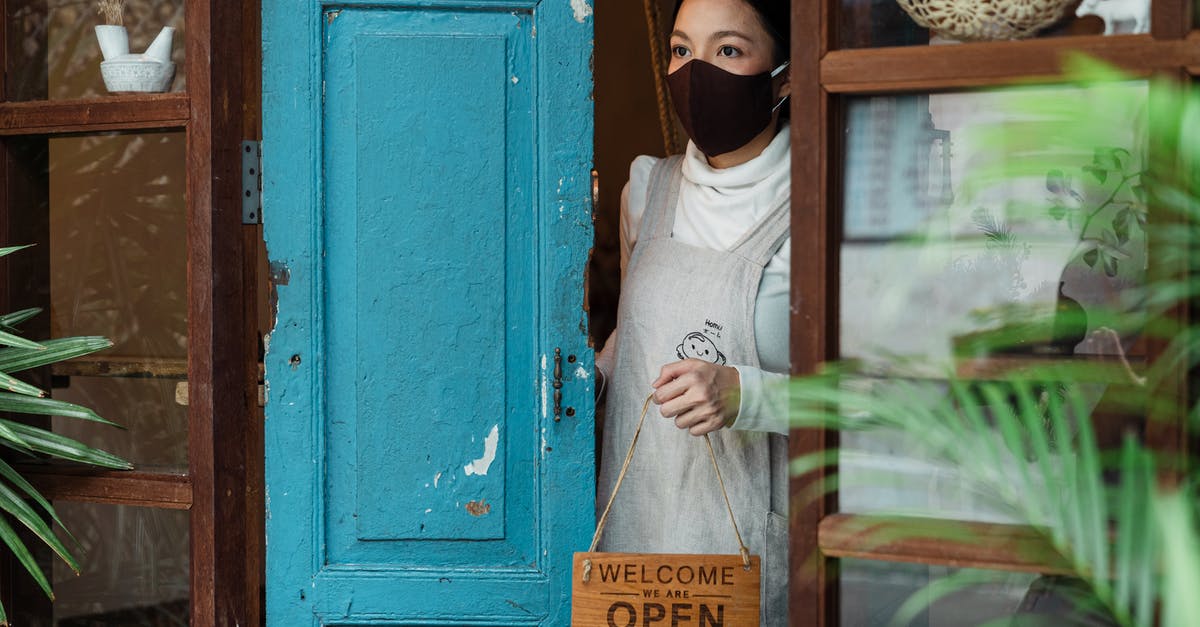 Will the Bourbon Tunnel in Naples be open for visitors on September 19? - Calm young Asian female wearing casual clothes and face mask standing at shabby rural shop doorway and removing open sing