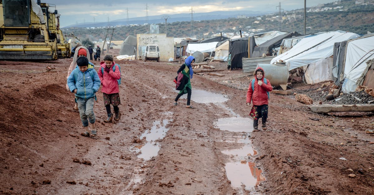 Will this small crease in passport be a problem - Poor children walking on muddy ground in settlement with tents