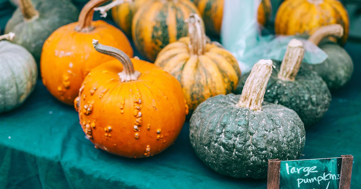 Withhold number when calling local numbers in Vietnam - Colorful raw pumpkins with pedicels on green cloth with price tag in local bazaar in daytime