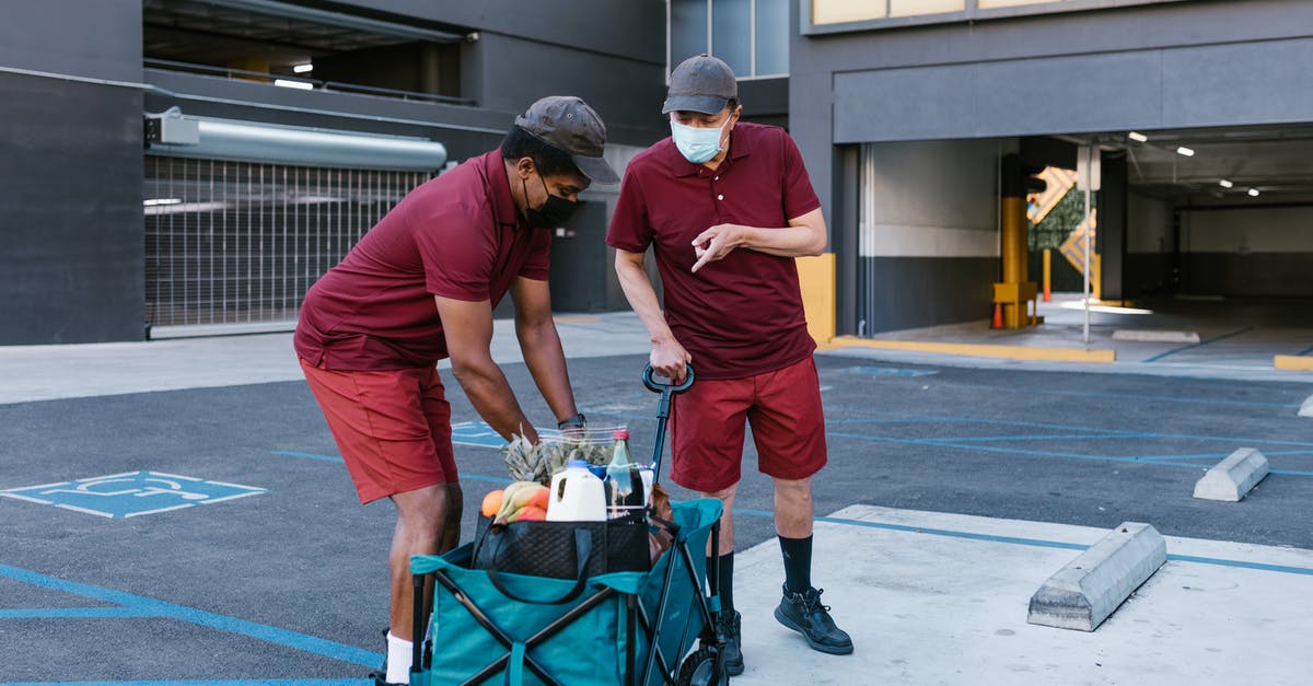 Wizz Priority trolley or handbag - Man in Red T-shirt and Orange Pants With Blue and Black Bag on Black and