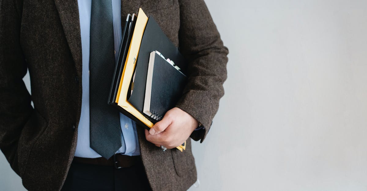 Working for US client as a UK company director in the US - Crop unrecognizable office worker standing with papers in hand