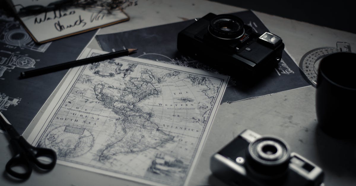 World map and photo storage - Electronic devices and paper map on table