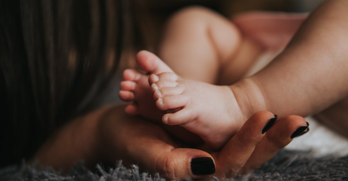 Would a parent's citizenship affect a UK visa application for their children? [closed] - Person Holding Baby's Feet in Selective Focus Photography