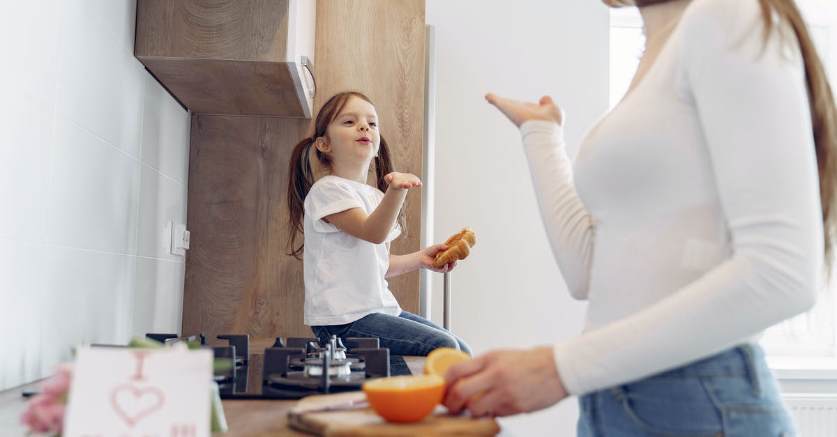 Would I be able to communicate in Vienna in German? - Loving mother and daughter blowing kiss on kitchen