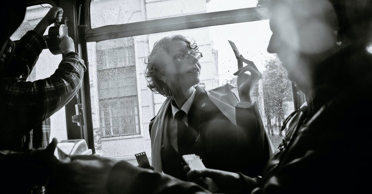 Would travel by bus count as an onward ticket? - Black and white of woman near crop male passenger using ticket puncher in retro vehicle during trip