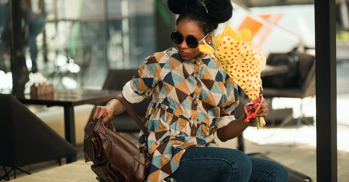 Yellow fever vaccination for airport transfer? [closed] - Photograph of Woman Seating on Table Holding Bouquet of Flowers