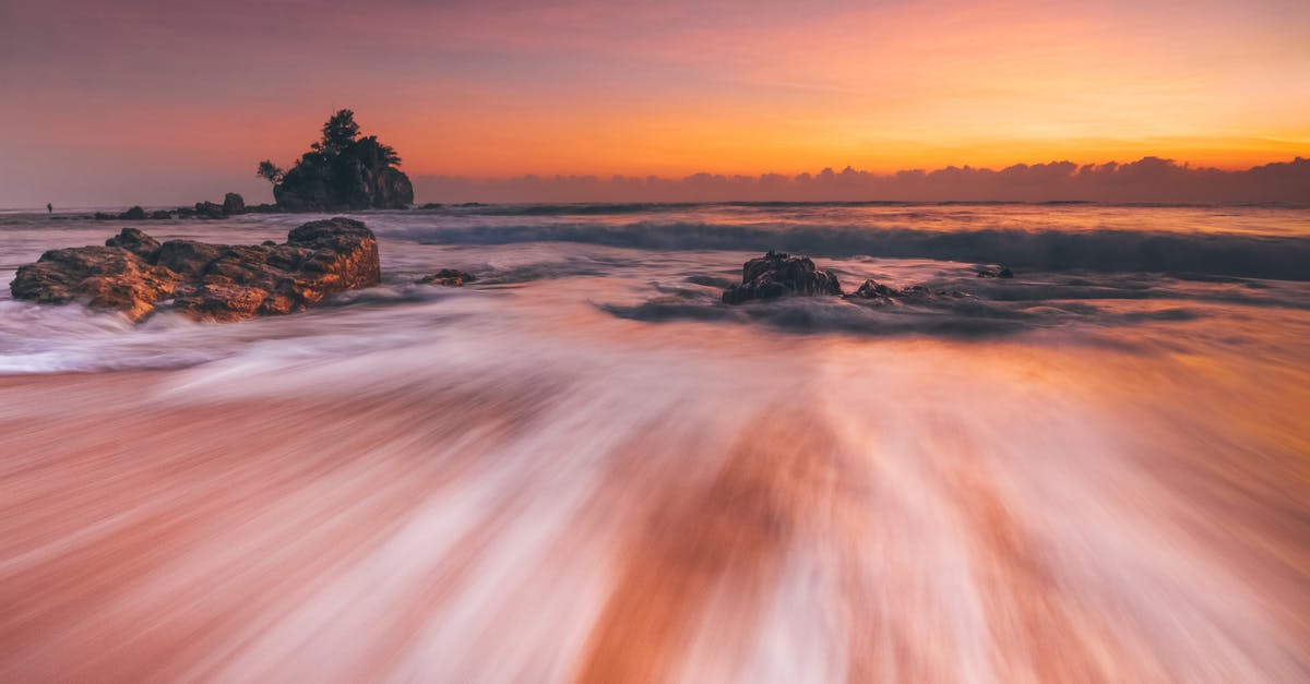 Yogyakarta to mount Merapi by scooter, possible? - Stormy sea with fast water flow on beach at sunset